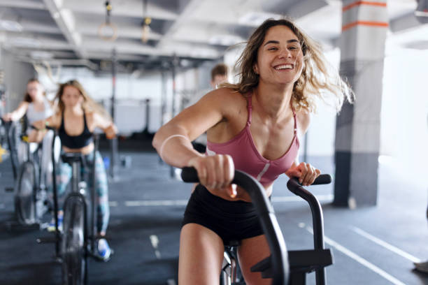 強くて健康な人々が運動している - spinning gym exercising cycling ストックフォトと画像