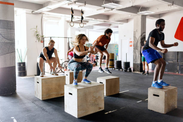 istock Group of multiracial people doing box jumps in the gym 1497023675