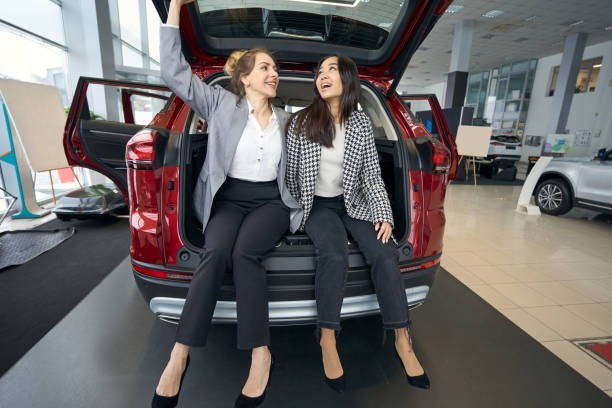 istock Two smiling women sitting in car trunk 1497028871