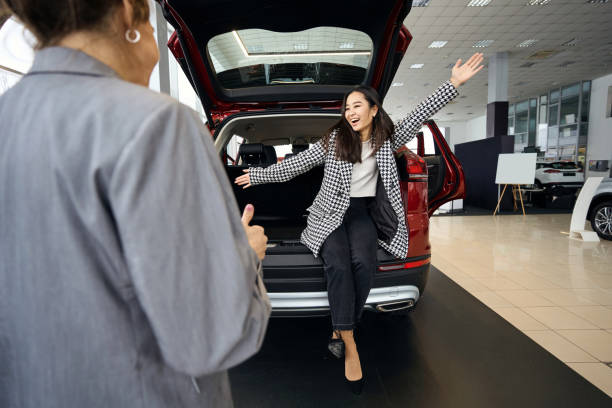 istock Happy lady with outstretched arms sitting in car trunk 1497028884