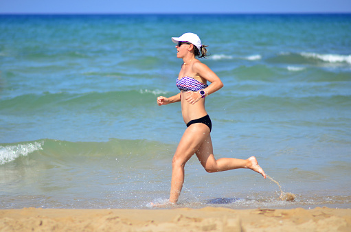 Woman exercising by running on the beach
