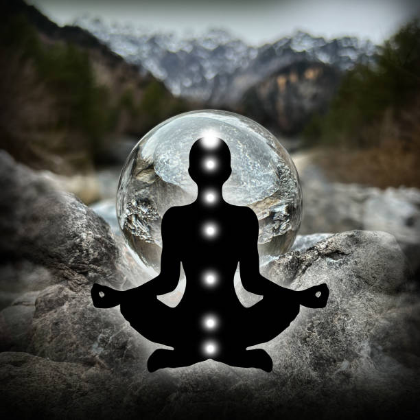 Human silhouette in yoga, lotus pose (human energy body, aura) in front of lensball, crystal ball (austrian alpine creek/landscape, Montafon) stock photo