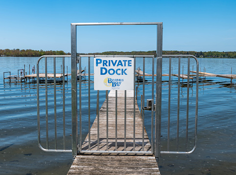 Beemus Point, New York, USA May 11, 2023 A closed gate on a private pier on Lake Chautauqua on a sunny spring day