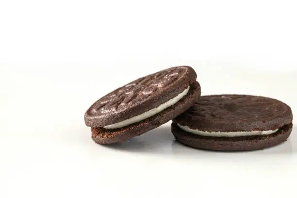 Close-up of sandwich chocolade cookies with milky cream on white .isolated background