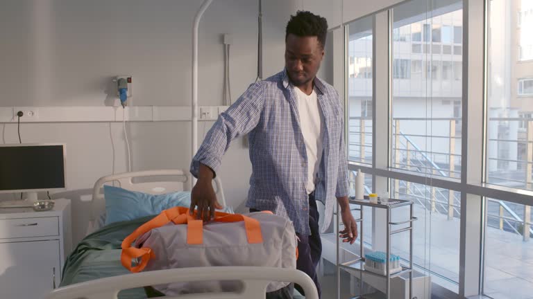 African-American male patient sign document on tablet being discharged from hospital