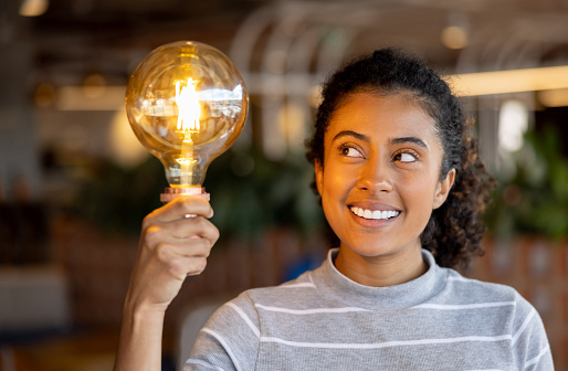 Portrait of a creative African American businesswoman having an idea and holding a light bulb