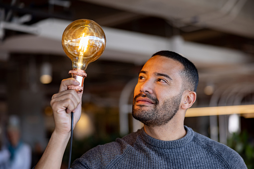 Portrait of a creative African American businessman having an idea and holding a light bulb