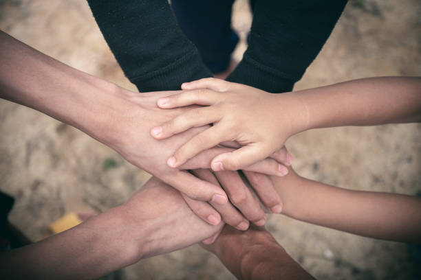 istock Family members join hands support together showing unity and teamwork concept. 1497058928