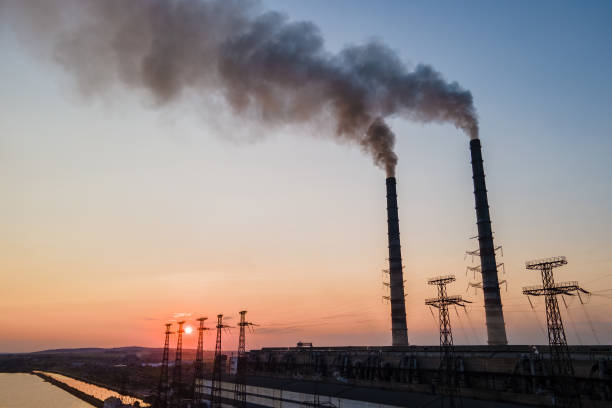 luftaufnahme der hohen rohre des kohlekraftwerks mit schwarzem rauch, der sich bei sonnenuntergang nach oben bewegt und die atmosphäre verschmutzt. erzeugung elektrischer energie mit fossilem brennstoffkonzept - vapor trail sky night sunset stock-fotos und bilder