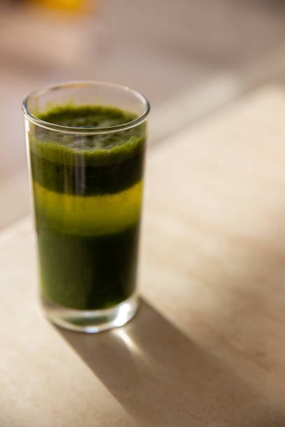 a glass of layered healthy green juice