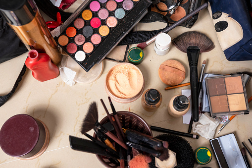 Makeup equipment are scattered on table
