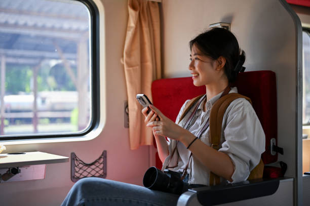 istock A happy Asian female traveler backpacker using her phone while sitting in her seat on a train. 1497076091