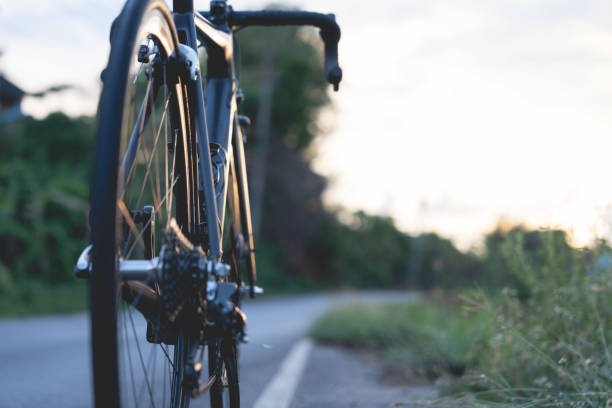 istock Road bike parked on a beautiful road sunset, warm light with copy space. 1497076333