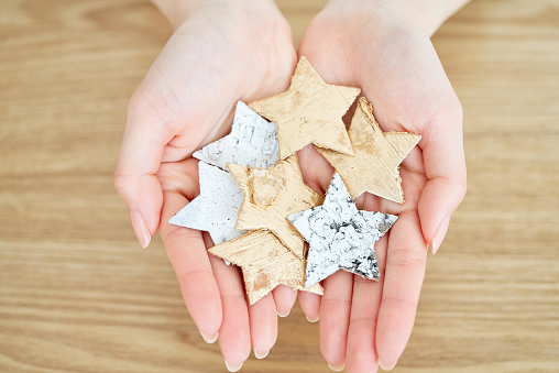 A woman's hands holding a star-shaped accessory on the table