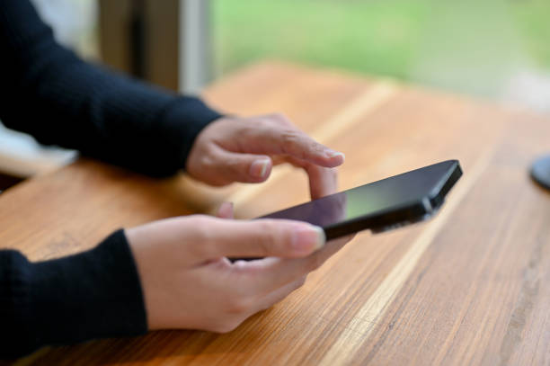 istock A female using her smartphone while sitting at a table by the window in the coffee shop. 1497077959