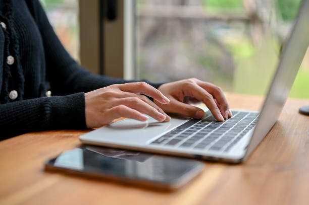 istock Close-up image of a woman using a laptop computer while sitting at a table in the coffee shop. 1497077962