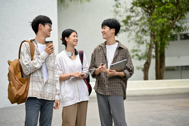 istock A group of cheerful Asian students enjoy talking while walking in the campus outdoor space. 1497078103