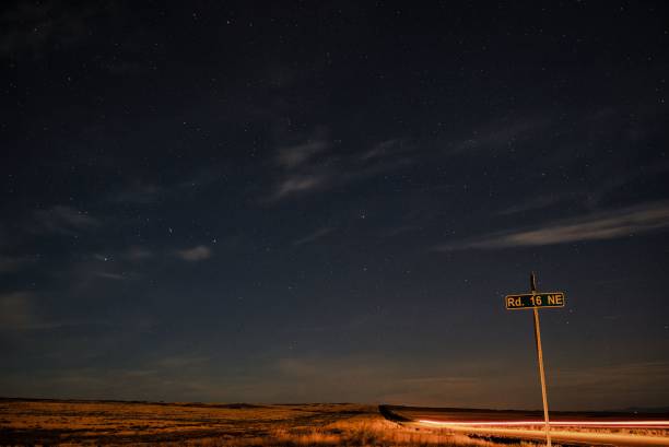 istock Roadway with a sign 'Rd. 16 NE' illuminated by the starry night sky 1497078369