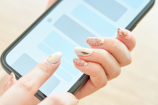 Hand of a woman who operates a smartphone