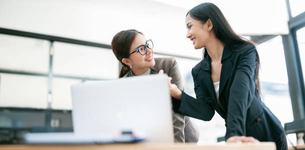 istock Working together on new project. Two young business colleagues working on computer at office. 1497080096