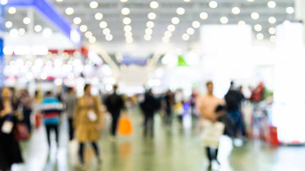 Abstract defocused crowd of people walking in exhibition