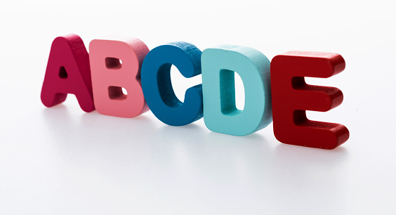 Wooden letters ABCDE on white background.