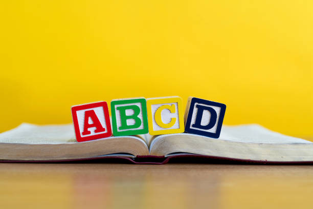Wooden letters ABCD on the book.