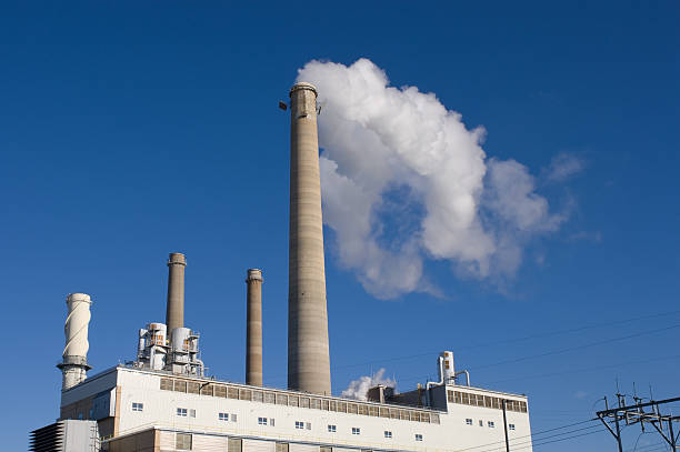 Power plant with smokestack and blue sky stock photo