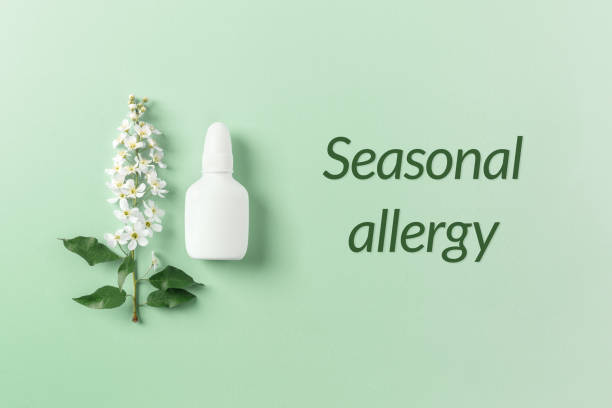 Seasonal spring allergies treatment concept, fresh spring blooming branches tree and mock up white nasal spray bottle on pastel green background, top view, minimal flat lay. Text Seasonal allergy. concepto de tratamiento de alergias estacionales de primavera, árbol de ramas florecientes de primavera fresca y maqueta de botella de aerosol nasal blanco sobre fondo verde, vista superior, colocación plana mínima. texto alergia estacional.