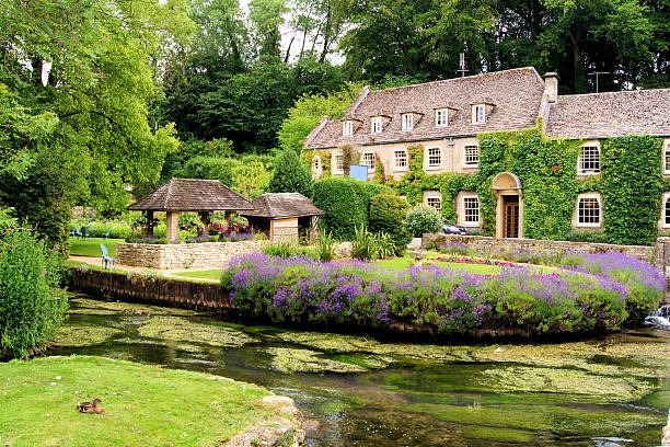 Garden in the English Cotswolds Picturesque garden in the Cotswold village of Bibury, England gloucestershire stock pictures, royalty-free photos & images