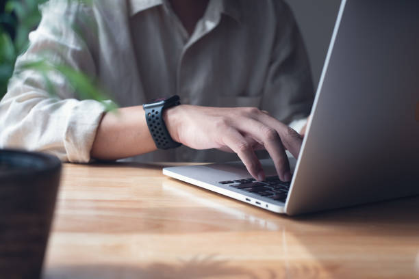 istock Business man working on laptop computer, typing on laptop keyboard on office table, surfing the internet, online job, online study, e-learning, working at home, telecommuting concept 1497098490