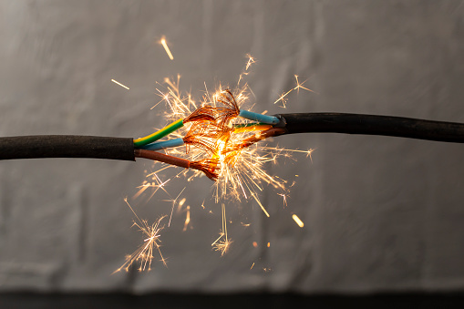 sparks explosion between electrical cables, fire hazard concept, soft focus close up