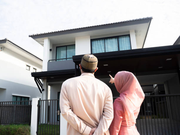 homeowners. back view of loving muslim couple pointing and looking at their dream house. - salé city imagens e fotografias de stock