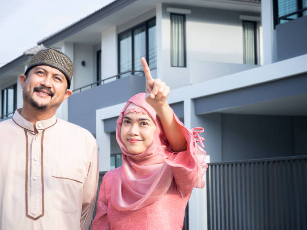 happy homeowners asian muslim couple pointing their new house. - salé city imagens e fotografias de stock