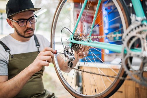 Owner of a small bike shop repairing vintage bicycle.