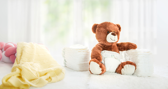 Toy teddy bear sitting on a bed