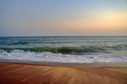 A tranquil beach of Indian ocean in Hambantota with foamy waves at sunset