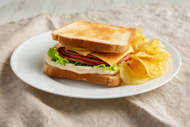 istock Homemade Fried Bologna and Cheese Sandwich with Chips on a Plate, low angle view. 1497110144
