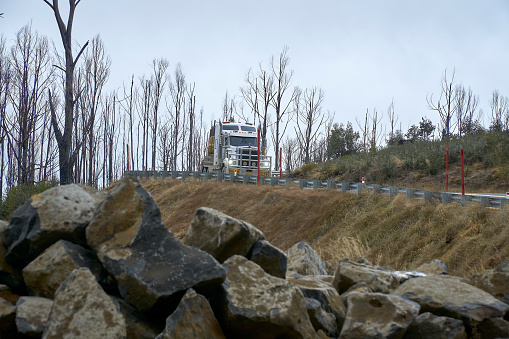 Oversized machinery Load on the Snowy Highway. a bog truck climbing Sawyers hill on a cloudy winters day