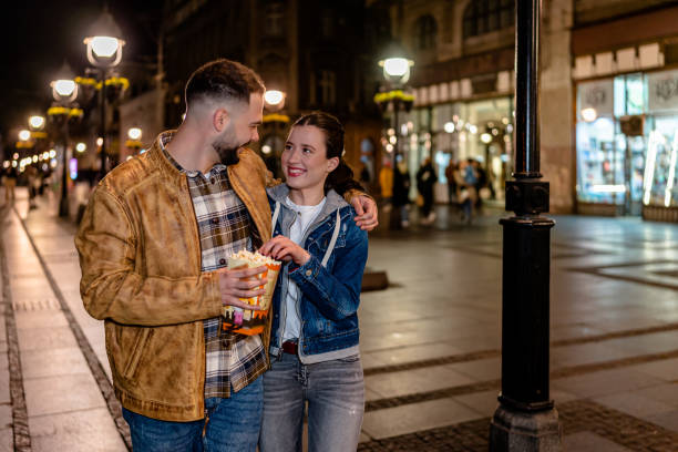 istock Couple Walks and Munches on Popcorn 1497114663