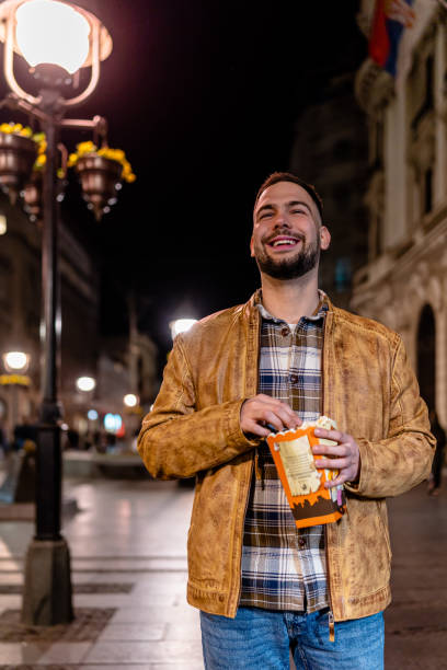 istock Young Man Recharges with a Snack During Evening Walk 1497115430