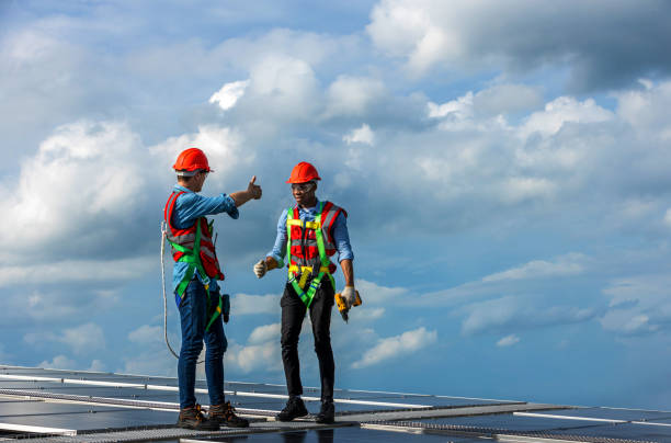 istock Engineer working setup Solar panel at the roof top. Engineer or worker work on solar panels or solar cells on the roof of business building 1497116299