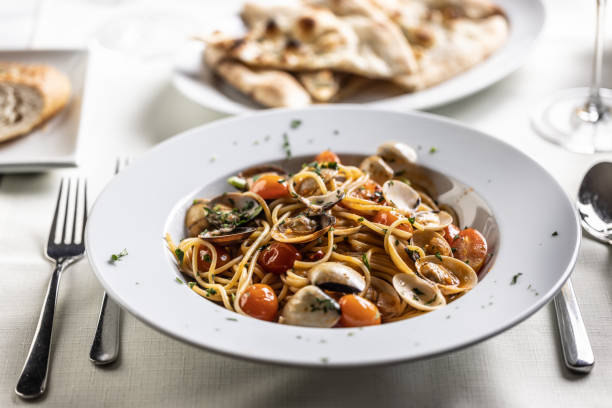 istock Plate full of spaghetti alle vongole e pomodorini served on a restaurant table. 1497118715