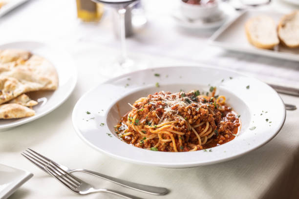 istock Restaurant serving of spaghetti bolognese with grated cheese on top on a white table. 1497119312