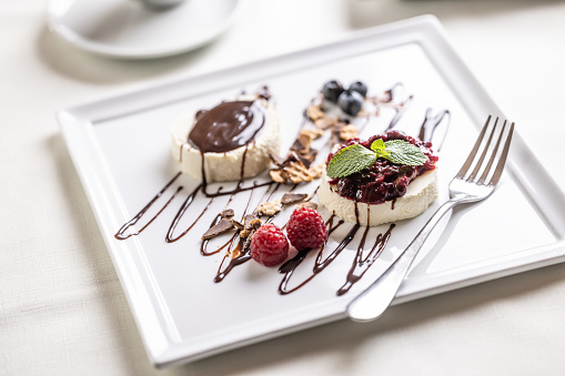 Sweet dessert panna cotta from Italy served on a decorated plate with fruit and chocolate.