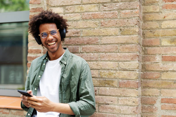 Handsome young man with headphones. Man listening the music while walking through the city.
