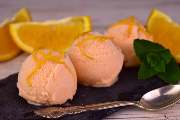 istock Orange ice cream. Orange ice cream balls on a black slate board. 1497126328