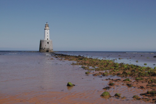 White lighthouse at low tide