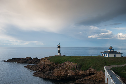 Access to the Isla Pancha lighthouse in Ribadeo-Lugo with clouds threatening spring storms