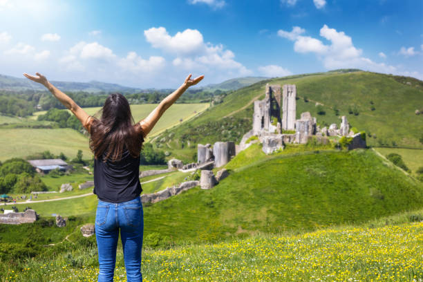 ドーセットのコーフ城の廃墟を見る観光客の女性 - corfe castle ストックフォトと画像